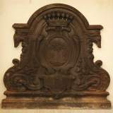 Старинная каминная плита, декорированная  гербовым щитом и головами борзых.