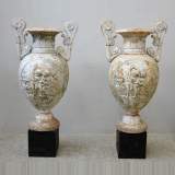 Пара старинных чугунных ваз, украшенных амурчиками.